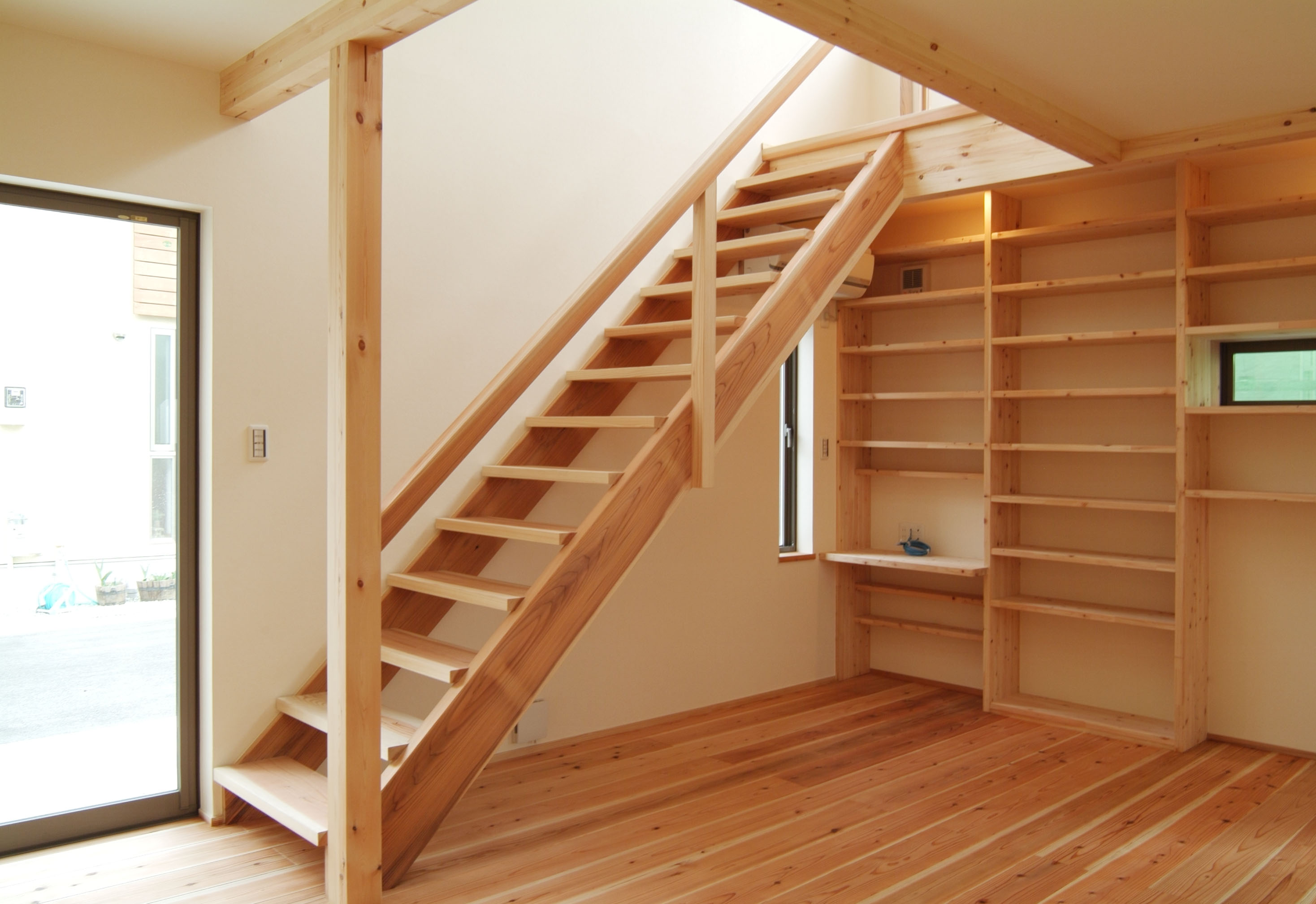 国産杉無垢材を使った造作階段：バイクガレージと本棚のある家：池田住宅建設 木の家施工例