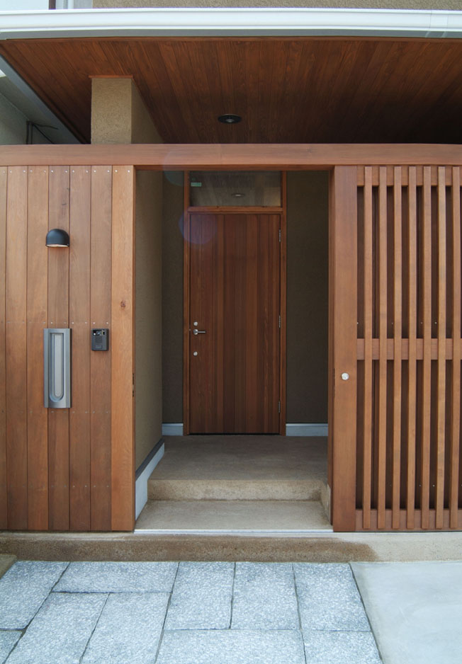 玄関前の格子戸と米杉の玄関ドア 杉にこだわった現代風の田舎家 池田住宅建設 木の家施工例